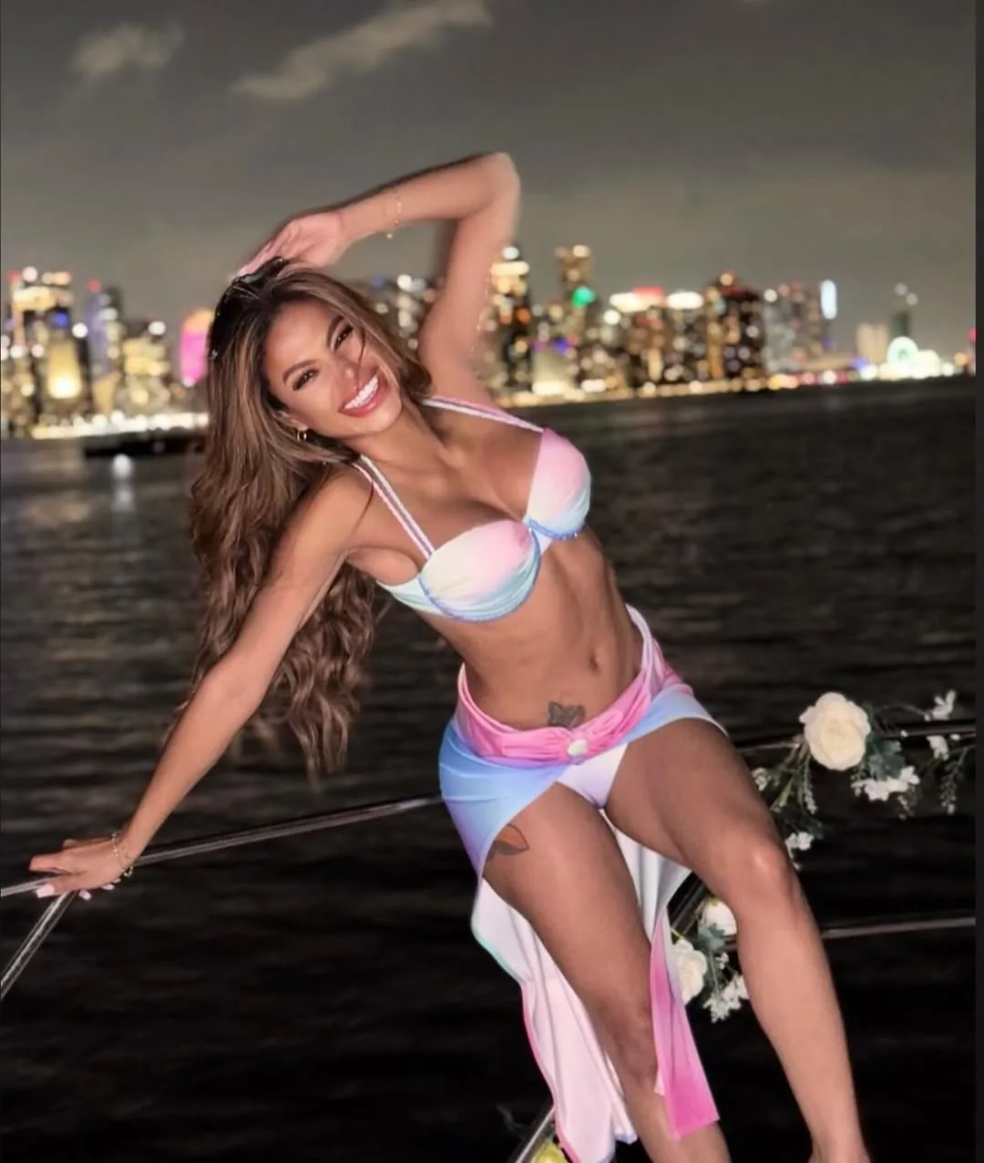 Birthday charter guest aboard the Pink Panther at night with the Miami skyline behind